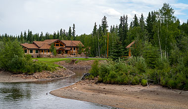 A house in a forest by a river in Alaska