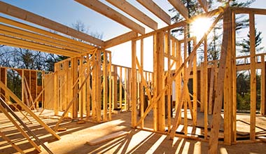 Construction loan ad Framing a home with sunlight shining in the background